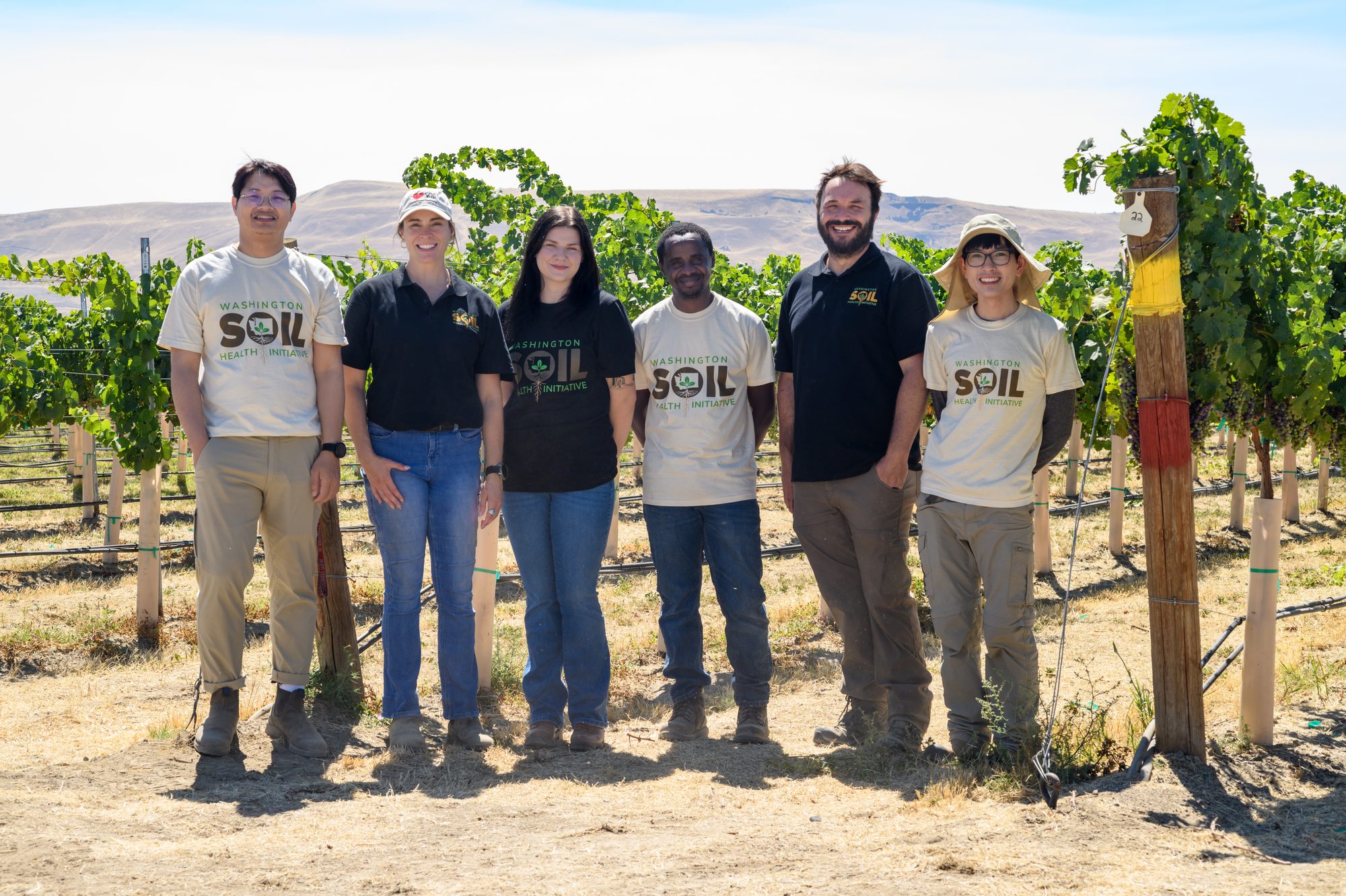 Worasit with members of the Functional Soil Health Lab standing in a vineyard in Washington